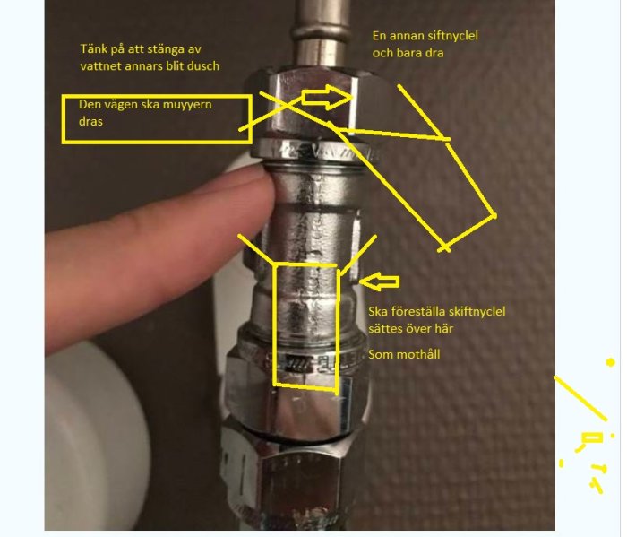 Anvisning för att använda skiftnyckel på rördel markerad med hand och instruktionspilar.