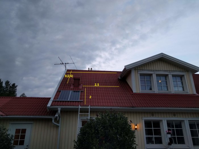 Solceller monterade på rött tegelpanneliknande plåttak med måttmarkeringar.