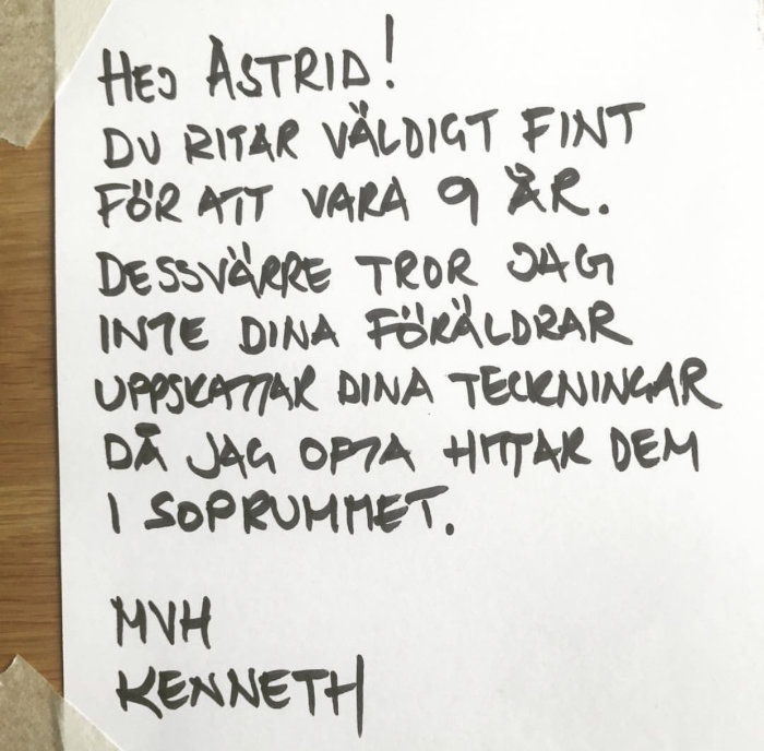 Handskriven lapp där någon vid namn Kenneth berömmer Astrid för hennes teckningar men nämner att de ofta hamnar i soprummet.