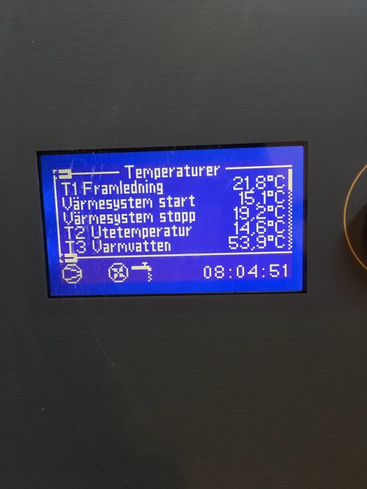 Digital display visar temperaturer för ett värmesystem med tider och olika värden.