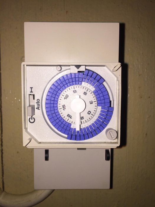 Tidur för utomhusbelysning med inställbara tidsintervaller på en vit vägg.
