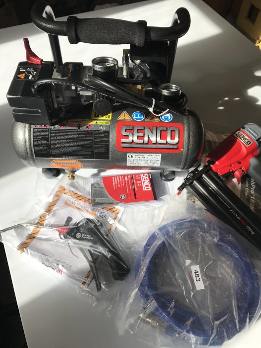 SENCO luftkompressor med tillbehör som spikpistol och slangar, nyköpta från Verktygsproffsen för 3085 kr.