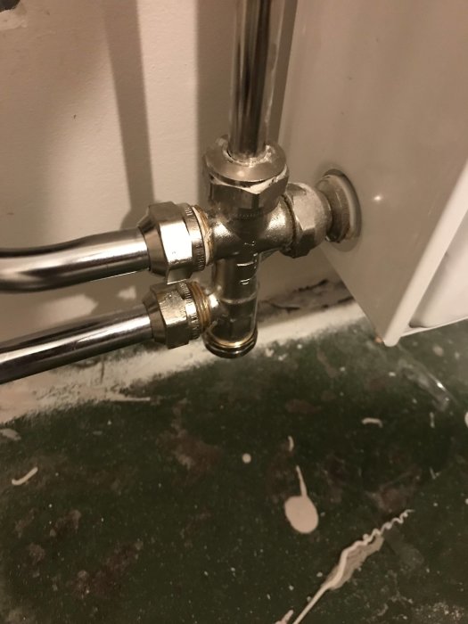 Anslutningsdetaljer på en radiator med ett hett kopparrör och installationsproblem.