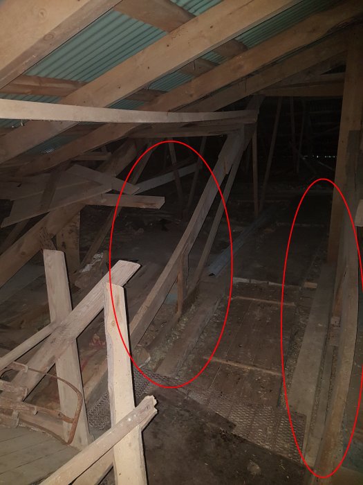 Två markerade skeva takreglar i en byggnad med takstolar och svag lutning.