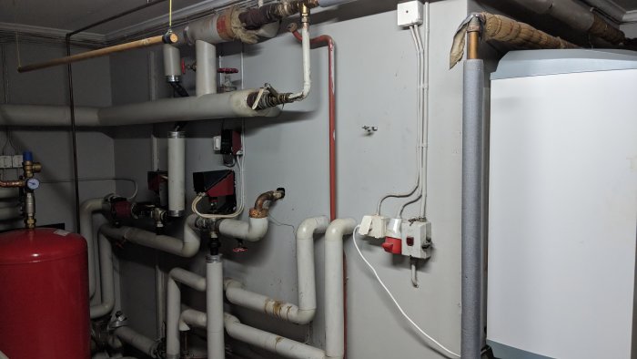 Pannrum med olika rörinstallationer, cirkulationspump, expantionskärl och en varmvattenberedare.