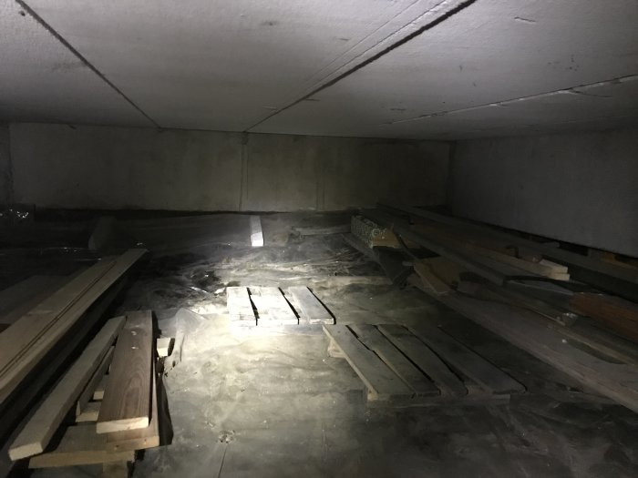 Torr krypgrund med betongbjälklag och trävirke, möjlig plats för golvvärmeinstallation.