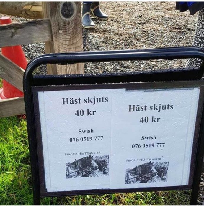 Skylt med texten "Häst skjuts 40 kr, Swish 076 0519 777" mot en bakgrund av folk i stallmiljö.