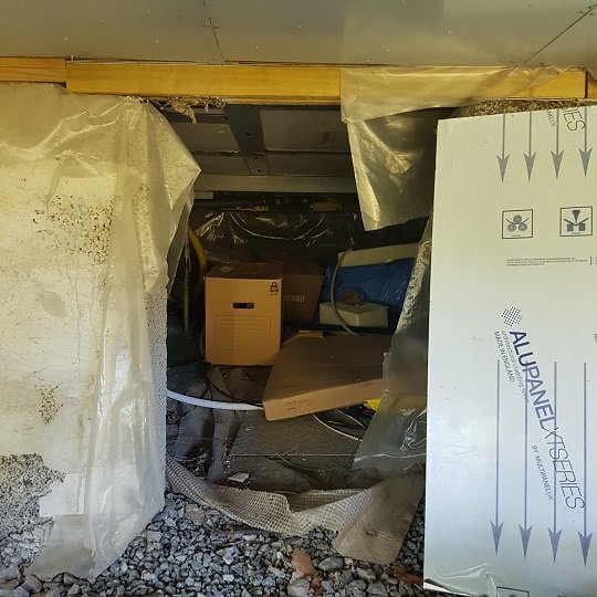 Torpargrund under gäststuga med lecablock, varmvattenberedare och pumpstation synliga.
