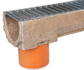 Markränna av betong med metallgaller ovanpå kopplad till orange avloppsrör.