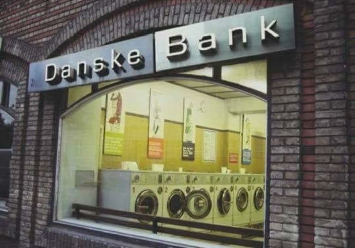 Skylten "Danske Bank" över ett fönster som visar en interiör med tvättmaskiner, en ordlek på bank namnet.