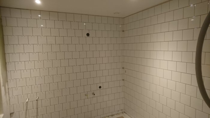 Våtrum under renovering med halvstensförband kakel och förberedelser för valv över fönster.