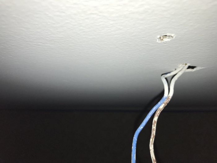 Takmålning nära elektriska kablar och hål i gipsvägg, efter applicering av spärrfärg.