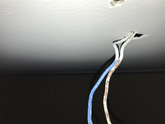 Elektriska kablar sticker ut från hål i taket efter applicering av spärrfärg.