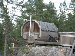 Bastutunna i trä placerad på klippor i skogsmiljö.