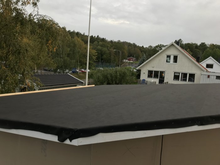 Nyinstallerat svart takpapp på byggnad för väderskydd mot västkustklimat.