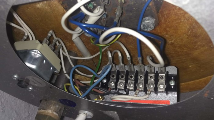 Interiör av elektrisk anslutningsdosa med trådar och anslutningsklemmar, oanvänd blå kabel synlig.