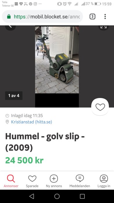 Gammal grön golvslipmaskin av märket Hummel till salu på stenläggning framför dörr.