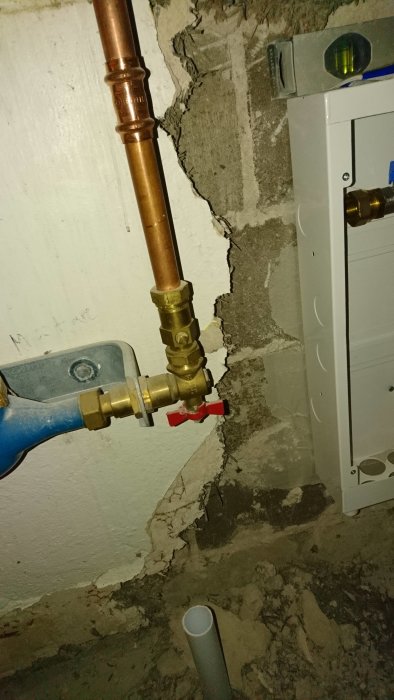 Kopparrör med pågående röranslutning till vattenmätare, inkluderar förminskande koppling och blått PEX-rör.