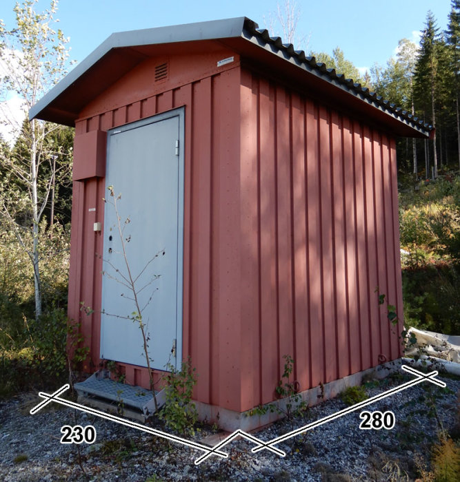 Rostfärgad liten nätstation med vita dörrar och svart tak omgiven av vegetation, märkt med dimensionerna 230 och 280.