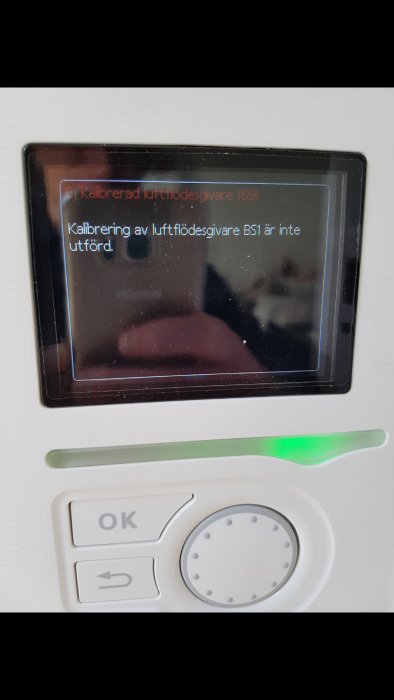 Display på en värmepump med felmeddelandet "Kalibrering av luftflödesgivare BS1 är inte utförd".