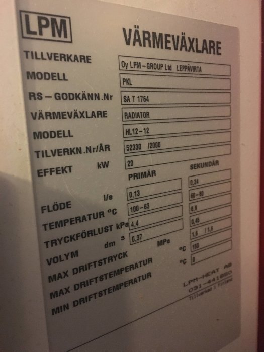 Informationsetikett för en LPM värmeväxlare med tekniska specifikationer och modellnummer.