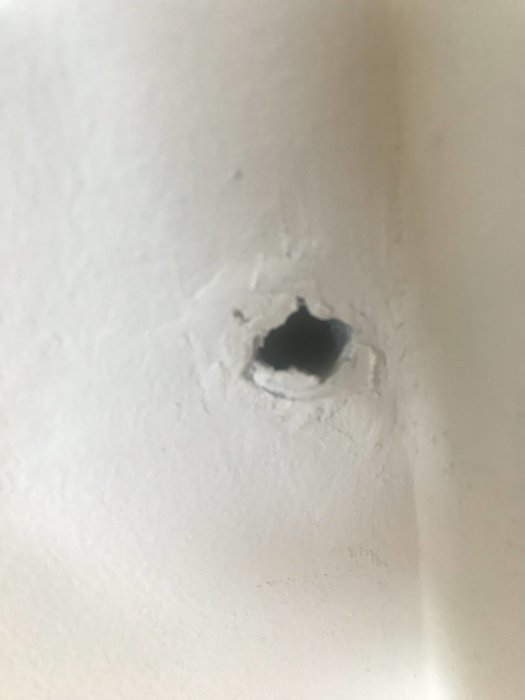 Plaströr som sticker ut ur en vitmålad vägg i ett penthouse.