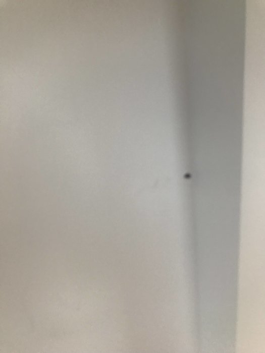 Två små plaströr som sticker ut från en vit vägg i ett penthouse.