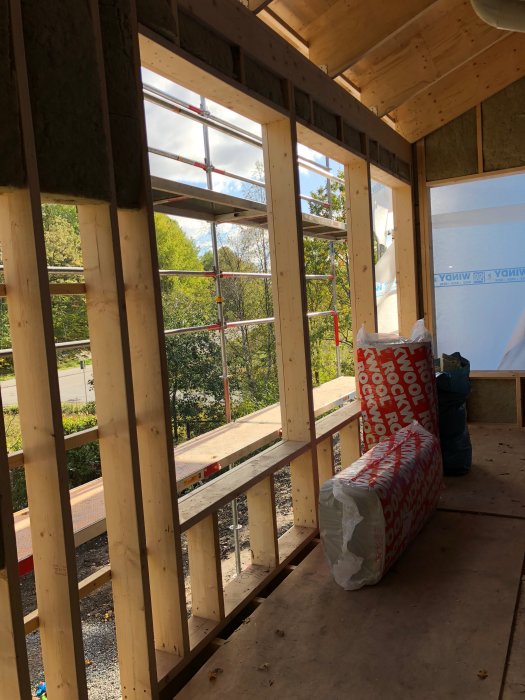 Hus under renovering med synlig träregelstomme och isoleringsmaterial vid vägg.