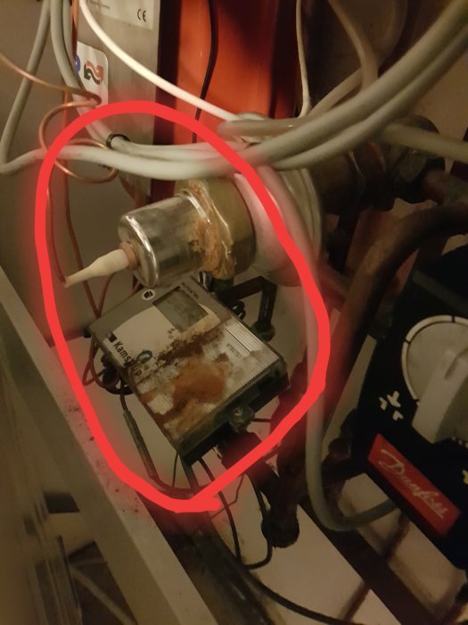 Trasig Cetetherm U21 värmeväxlare med rost och rostdroppar på displayenheten, inringat med rött för tydlighet.