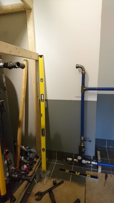 Installation av VA-rör på en byggplats med nivåinstrument och verktyg synliga.