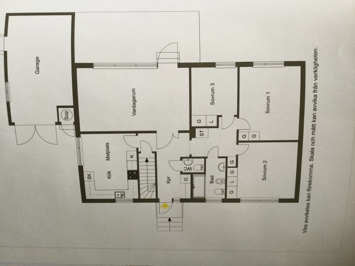 Planritning över en tvåvåningsvilla med markerad placering för kamin i vardagsrummet.