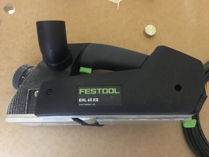 Festool EHL 65 EQ elhyvel på ett arbetsbord täckt med sågspån.