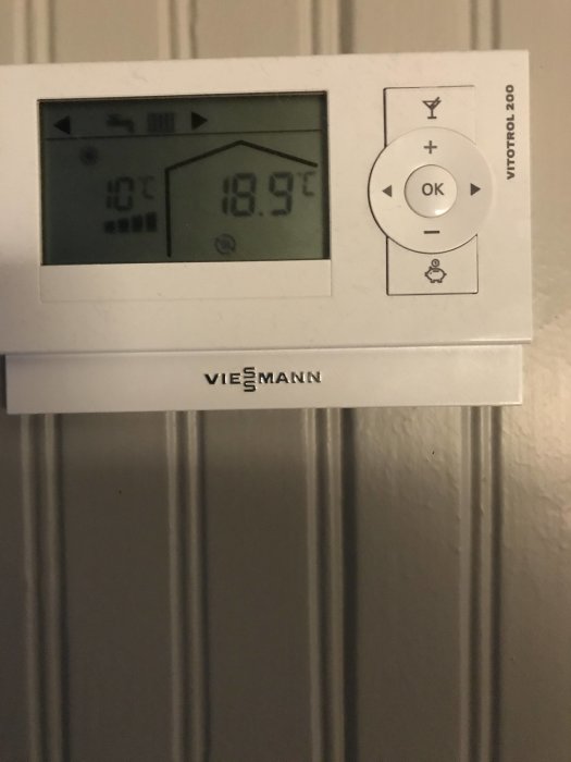 Digital termostat för rumsvärme visar innevarande temperatur 19.7°C på en Viesmann-enhet.