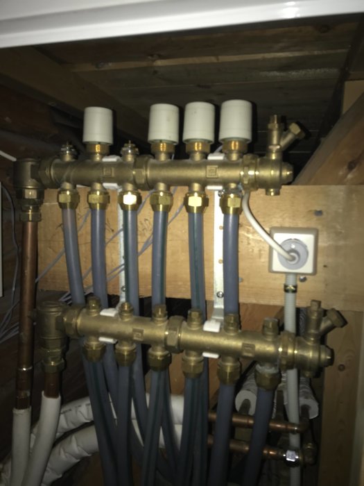 Installation av rörsystem med kopparledningar och fördelningsblock i en krypgrund.