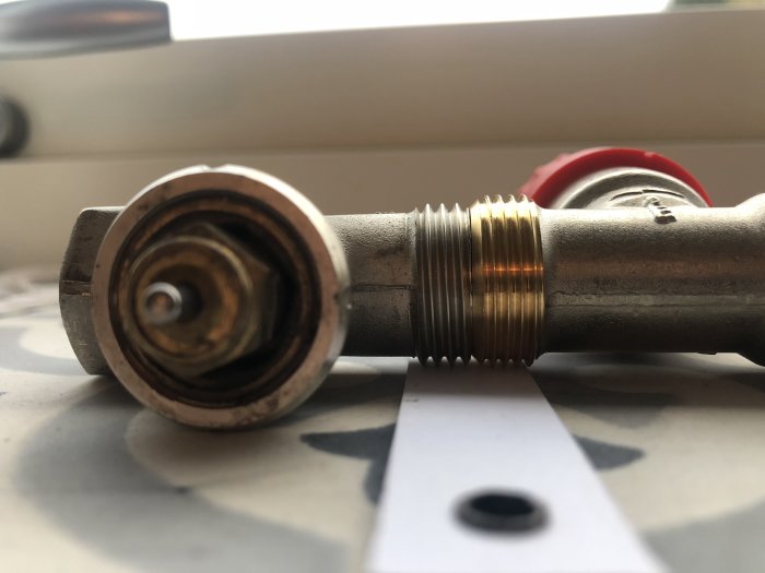 Gammal och ny ventildel till element, den gamla till vänster, jämförs i närbild.
