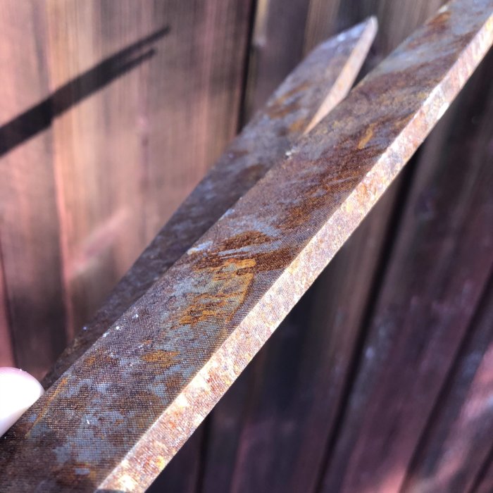 Närvarande bild visar en härdad och glashård smidesmärkkniv mot träbakgrund, innan anlöpning för flexibilitet.