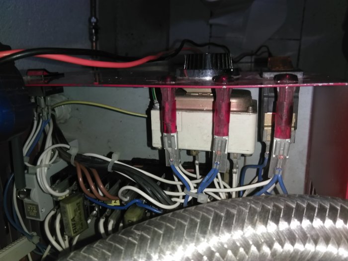 Interna komponenter av en elpanna med synliga kablar och termostatanslutningar.