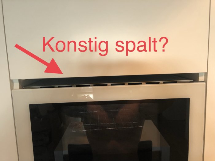 Inbyggd mikrovågsugn i köksskåp med stor glipa ovanför och tråkig spalt nedanför, markerad med text "Konstig spalt?