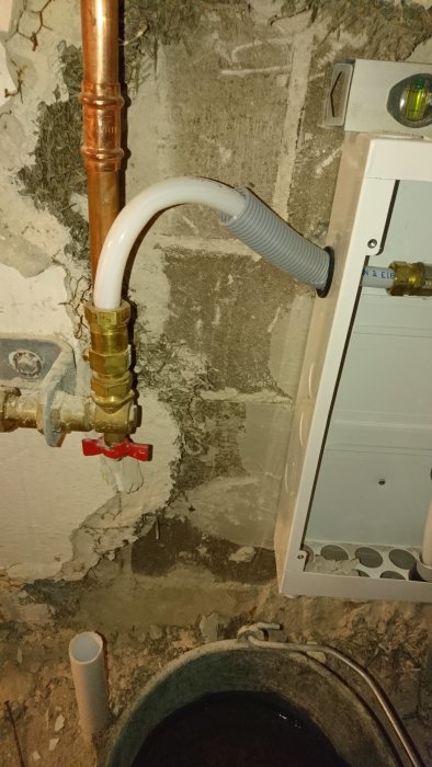 Installation av vattenskåp och rördragning i källare med märkning för att visa att avloppsröret är rakt.