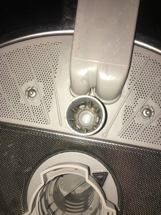 Närbild på en diskmaskins inre med övre spolarm i stängt läge täckt av tvättmedelsrester.