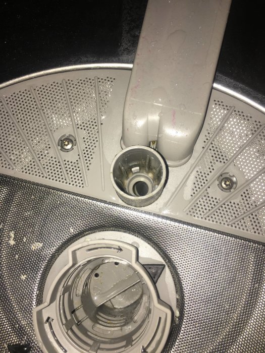 Inre delen av en diskmaskin med öppen och sannolikt fastnat spolarm.