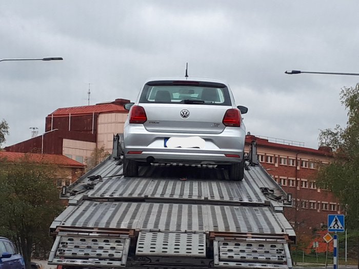 Volkswagen Polo lastad bakåtvänd på en bärgningsbil, ser osäkrad ut.