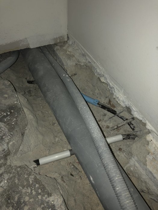Elledningar som går genom väggen och pansarrör i ett område under renovering.