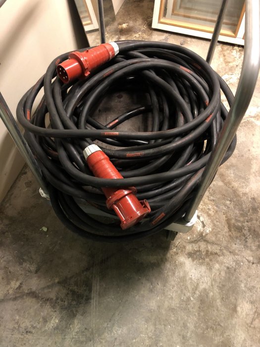 Motorkabel av märket Titanex uppdragen på en vagn med synligt rött 63a skarvuttag.