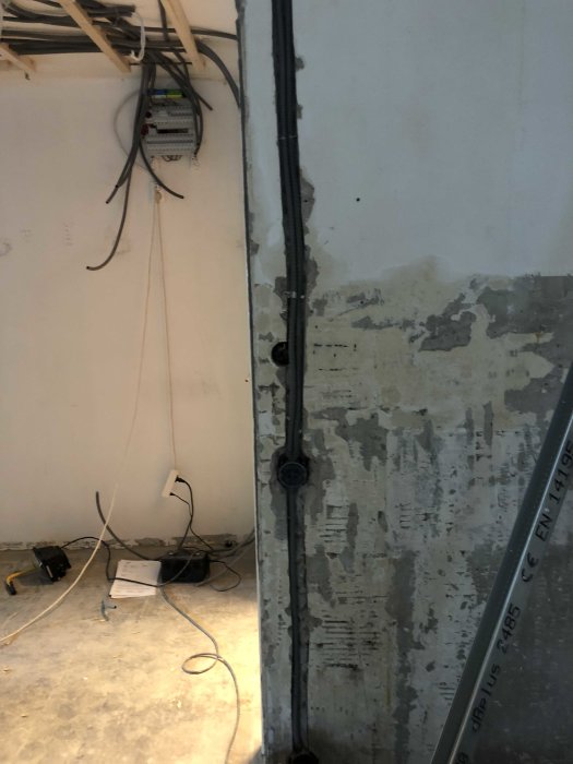 Orenoverat rum med elektriskt installationsarbete, blottade kablar och skadat väggytskikt.