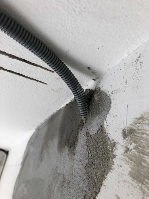 Korrigering av elrör som är ilagt i väggen med spackel runtomkring.