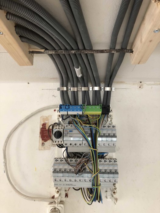 Installation av elektriska kabelrör och säkringslådor på en vägg i en byggnad.