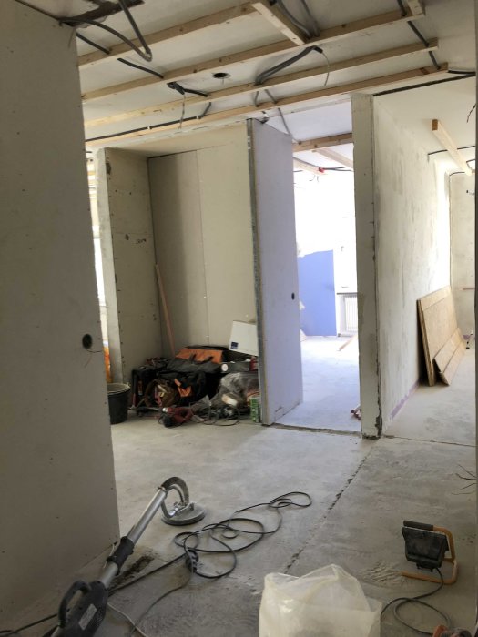 Renoveringsprojekt med gipsskivor och byggmaterial i ett ofärdigt rum.