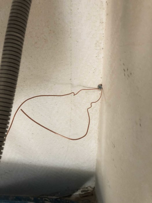 Eftersom du inte har försett någon text från inlägget, har jag ingen kontext att använda för att skapa alt-texten. Därför ska jag enbart beskriva vad bilden föreställer.
Alt-text: "Grov kopparkabel som löper längs en väggyta med en skruv i väggen.