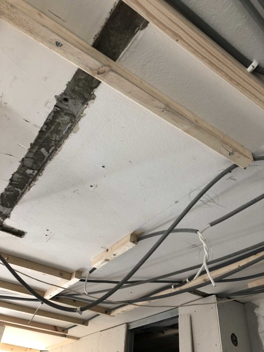 Tak i pågående renovering med synliga träreglar och genomdragning av elektriska kablar.